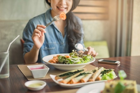 Young and happy woman eating healthy salad