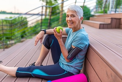 Sporty woman eating apple