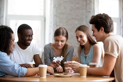 happy smiling mixed race friends sitting together