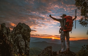 Young man hiker on a top of a mountain