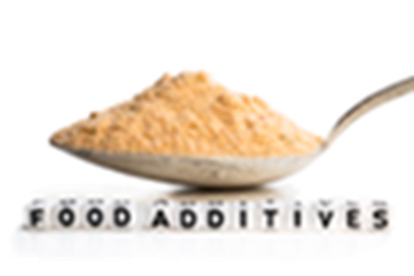 Spoon holding chemical powder with dice labeled "food additives"