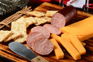 sausage crackers and cheese laid out on a wooden board