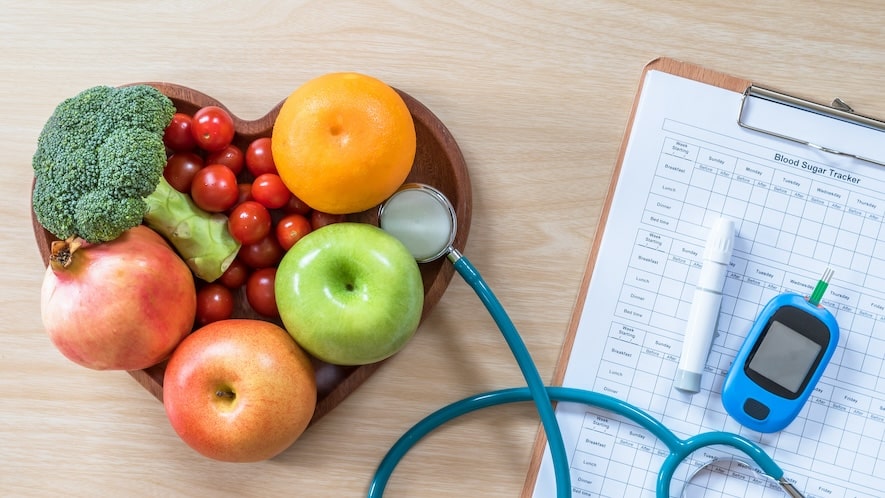fruit basket in shape of heart with stethoscope attached and blood sugar monitor nearby